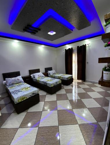 a room with two beds and a blue ceiling at Adem t3 f3 in 'Aïn el Turk