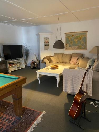 a living room with a couch and a table at Frederiksensminde Bed & Breakfast in Marrebæk