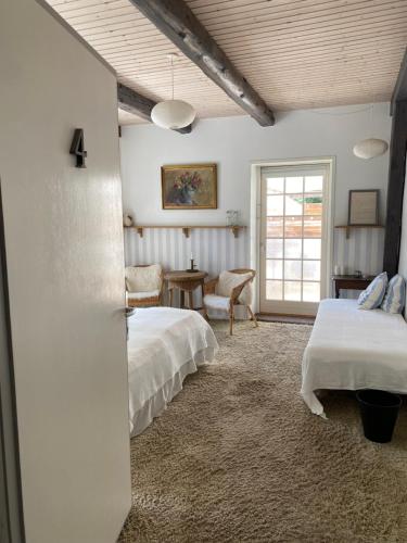 a bedroom with two beds and a table and a window at Frederiksensminde Bed & Breakfast in Marrebæk