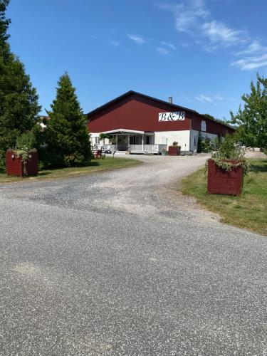 a barn with a road in front of it at Frederiksensminde Bed & Breakfast in Marrebæk