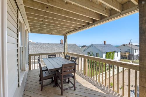 a wooden deck with a table and chairs on it at Swallows Nest in Kitty Hawk
