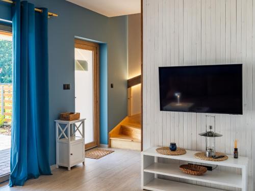 a living room with a flat screen tv on a wall at Pod Lasem Apartamenty in Łukęcin