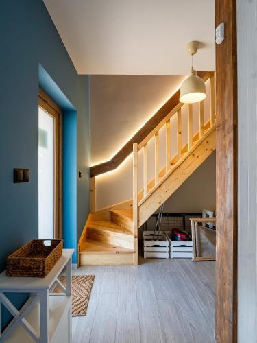 a staircase in a room with blue walls at Pod Lasem Apartamenty in Łukęcin
