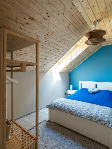 a bedroom with a bunk bed and a blue wall at Pod Lasem Apartamenty in Łukęcin