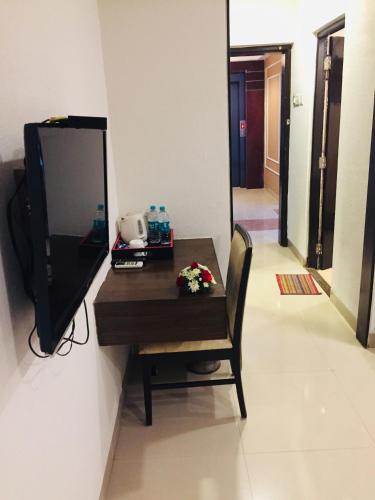 a room with a table with a television and a chair at HOTEL SUPREME (VASCO) in Vasco Da Gama