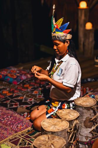 a woman sitting on the floor with a hat on her head at Burú Nature Hotel in Leticia