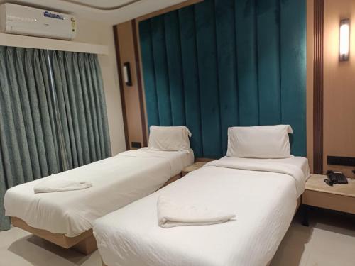 three beds in a hospital room with green curtains at HOTEL SUPREME (VASCO) in Vasco Da Gama