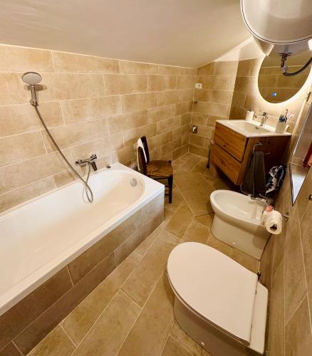 a bathroom with a tub and a toilet and a sink at Casa Altolaterra in Tagliacozzo