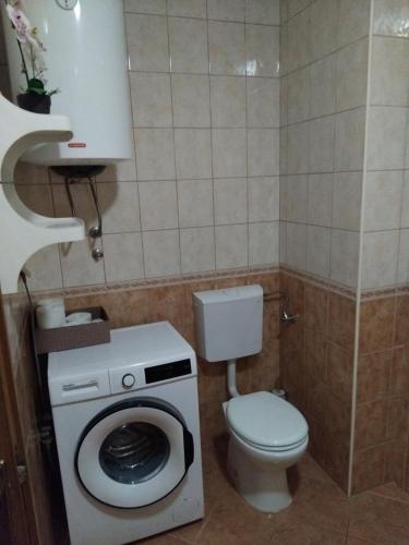 a bathroom with a toilet and a washing machine at Apartman Baška Voda in Baška Voda