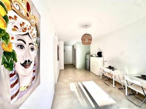 a room with a painting of a face on the wall at La Lume in Partanna