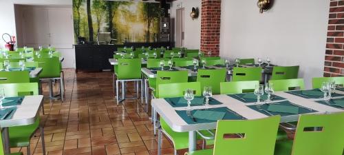 a room with green tables and green chairs at Ternelia Village vacances Sainte Montaine in Sainte-Montaine