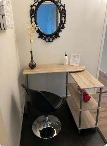 a desk with a black chair and a mirror at Doppingvägen 3 apartment 1 in Mariehamn