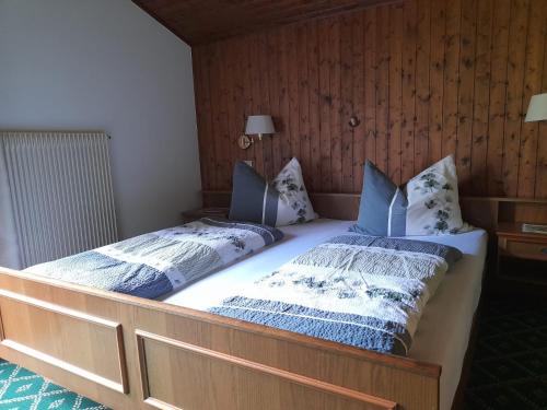 a bedroom with two beds with blue and white pillows at Haus Alpenheim in Braies