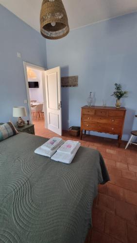 a bedroom with a bed with two towels on it at Pátio da Eira, Country House in Chamusca