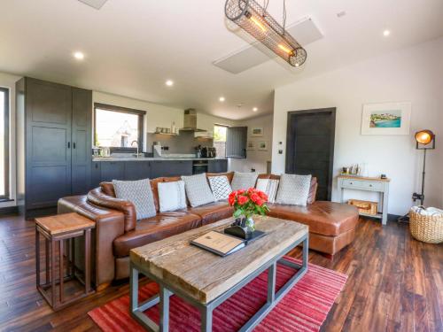 a living room with a couch and a table at Y Cwt in Moelfre