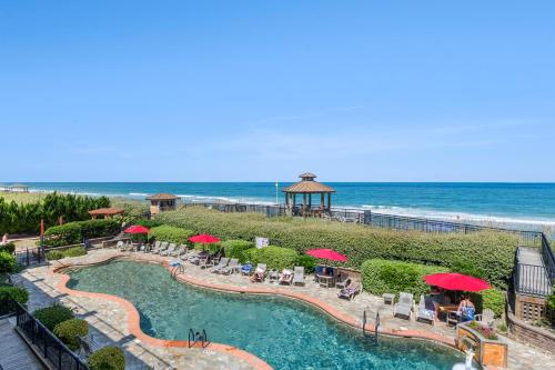 a resort with a pool and a gazebo and the ocean at Sweet Escape in Kill Devil Hills