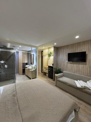 een woonkamer met een bank en een televisie aan de muur bij Vlora Studio in Vlorë