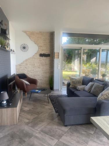 a living room with a couch and a chair at Maison vue panoramique et accès SPA in La Réole
