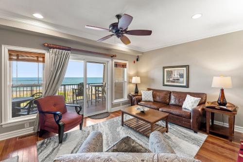 a living room with a couch and a ceiling fan at Sweet Escape in Kill Devil Hills