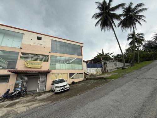 Un coche blanco aparcado delante de un edificio en AQ Rawang Inn, en Rawang