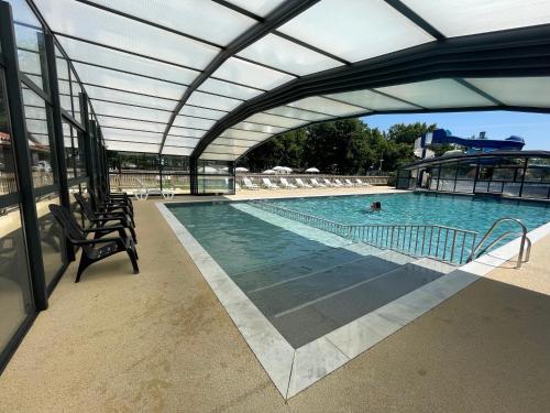 une grande piscine avec un toit rétractable dans l'établissement Nouveau Vacance nature au calme, à La Boissière-de-Montaigu
