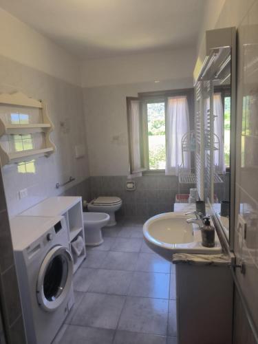 a bathroom with a sink and a washing machine at Villa Very II in Marina di Campo