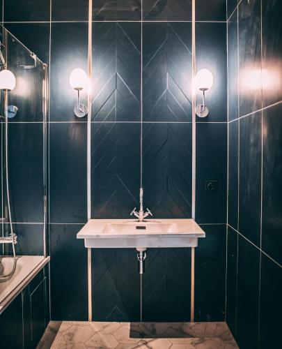 une salle de bain avec un lavabo et un miroir dans l'établissement Maison Marseille-Longchamp - Havre Art Déco & Business - Vieux-Port - Gare, à Marseille
