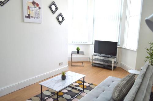 a living room with a couch and a tv at Brand New Lovely Flats by the Forest Tram Stop in Nottingham in Nottingham