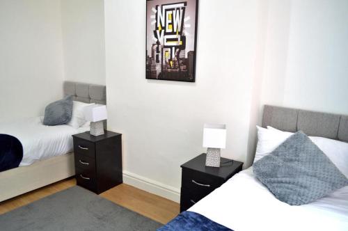 a bedroom with two beds and two lamps on night stands at Brand New Lovely Flats by the Forest Tram Stop in Nottingham in Nottingham