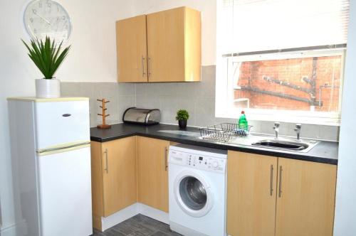 a kitchen with a washing machine and a sink at Brand New Lovely Flats by the Forest Tram Stop in Nottingham in Nottingham