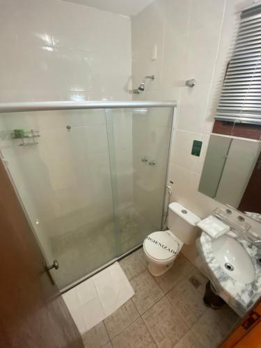a bathroom with a shower and a toilet and a sink at Hotel Fazenda Tucano in Capim Branco