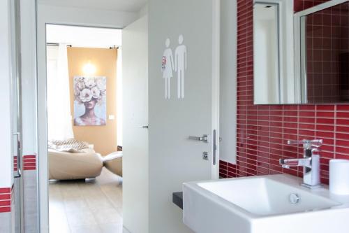 a bathroom with a white sink and red tiles at Daste Dream House in Bergamo