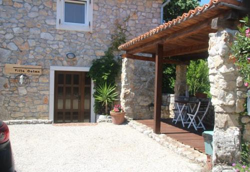a stone house with a wooden door and a patio at Villa Calma, recharge your body and mind in Gabonjin