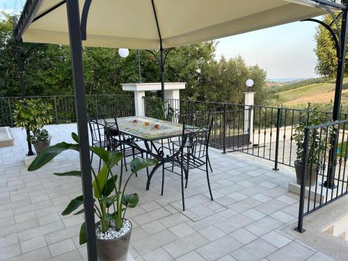 a table and chairs under an umbrella on a patio at Dimora i Mandorli 2 in Colonnella