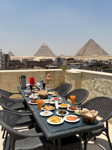 una mesa con platos de comida encima de una pirámide en Hasan Pyramids Hotel, en El Cairo