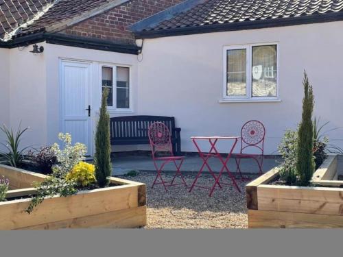 a house with two chairs and a bench in the yard at Horseshoe Cottage in Bridlington