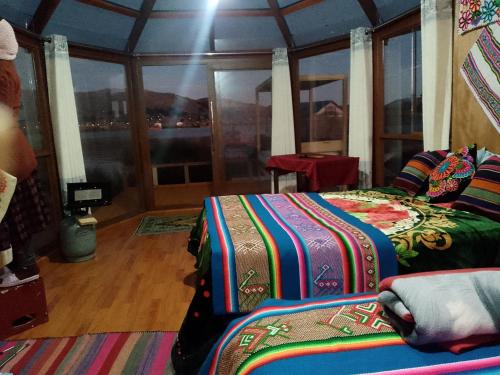 a room with two beds and a large window at Uros Titicaca coila lodge in Puno