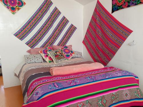 a bedroom with a bed with a comforter and pillows at Uros Titicaca coila lodge in Puno