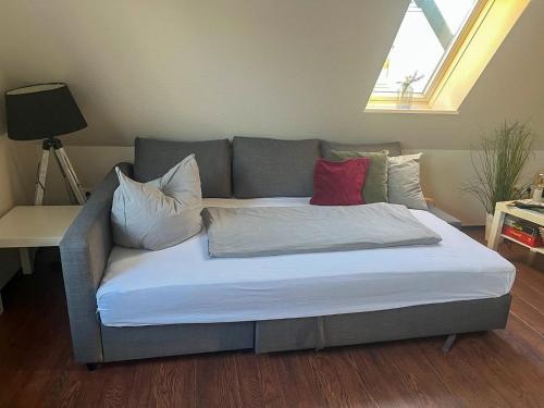 a bed with two red pillows on it in a room at Exclusives Apartment im Herzen von Westerland in Westerland (Sylt)