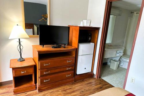 a bedroom with a tv and a dresser with a dresser at Econo Lodge Drums in Drums