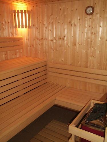a wooden sauna with a clock on the wall at Maison La Devinière - sauna et spa compris accessibles toute l'année in Xonrupt-Longemer