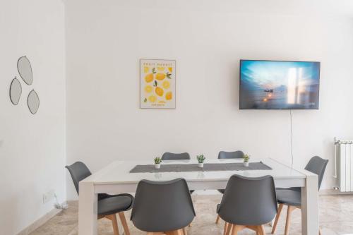 a white dining room with a white table and chairs at La Darsena Front lake apartment in Maccagno con Pino e Veddasca