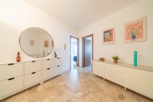 a white bathroom with a large mirror and white cabinets at La Darsena Front lake apartment in Maccagno con Pino e Veddasca