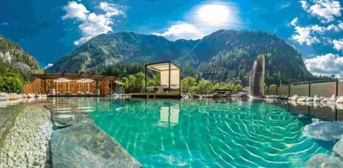 a pool of water with mountains in the background at Hotel-Restaurant Burgblick in Dorfgastein