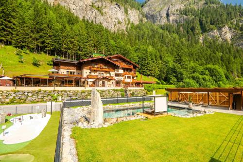 a resort with a pool in front of a mountain at Hotel-Restaurant Burgblick in Dorfgastein