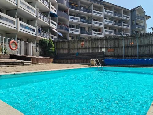 une piscine vide en face d'un immeuble dans l'établissement Terres de France - Résidence les Silènes, à Allevard