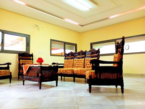 a room with chairs and a table and windows at Villa avec piscine privée hammamet bouficha in Bin Rhilouf