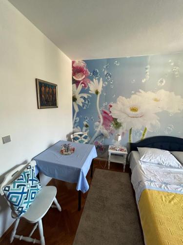 a bedroom with a bed and a table with a blue and white wall at Villa Nena in Herceg-Novi