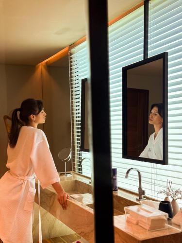 a woman standing in front of a bathroom mirror at Pousada Morena in Fernando de Noronha