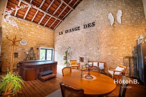 a living room with a wooden table and a piano at Rouge Tanin Cottage Private Spa Nature & Authentic Charm on a Dordogne in Blanc